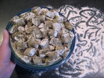 Nettle gnocchi on the counter in front of flour that someone had fun scribbling in, and that someone was me.