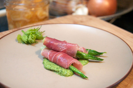 Young, roasted hosta shoots, wrapped in prosciutto and served on a bed of garlic mustard. Photo by Ellen Zachos.