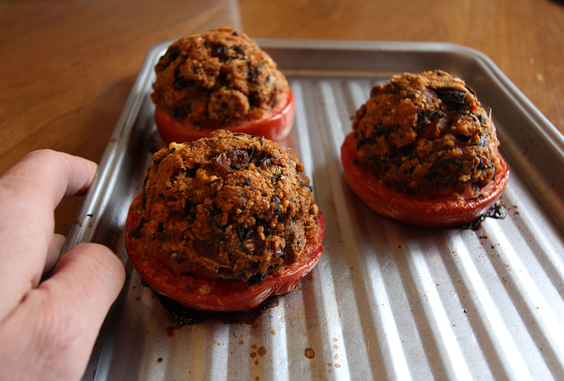 Tomatoes stuffed and roasted, the stuffing made from waterleaf and sausage, dock and onions, and leftover breadcrumbs.